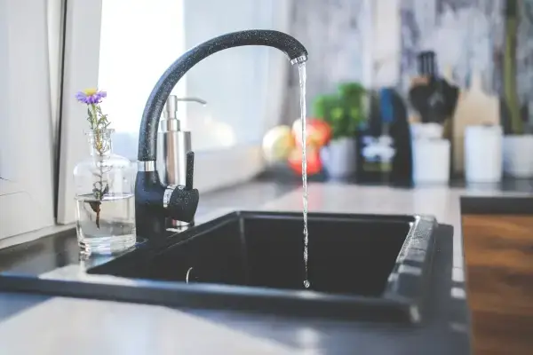 Weak flow of water from a kitchen tap, a sign of low water pressure